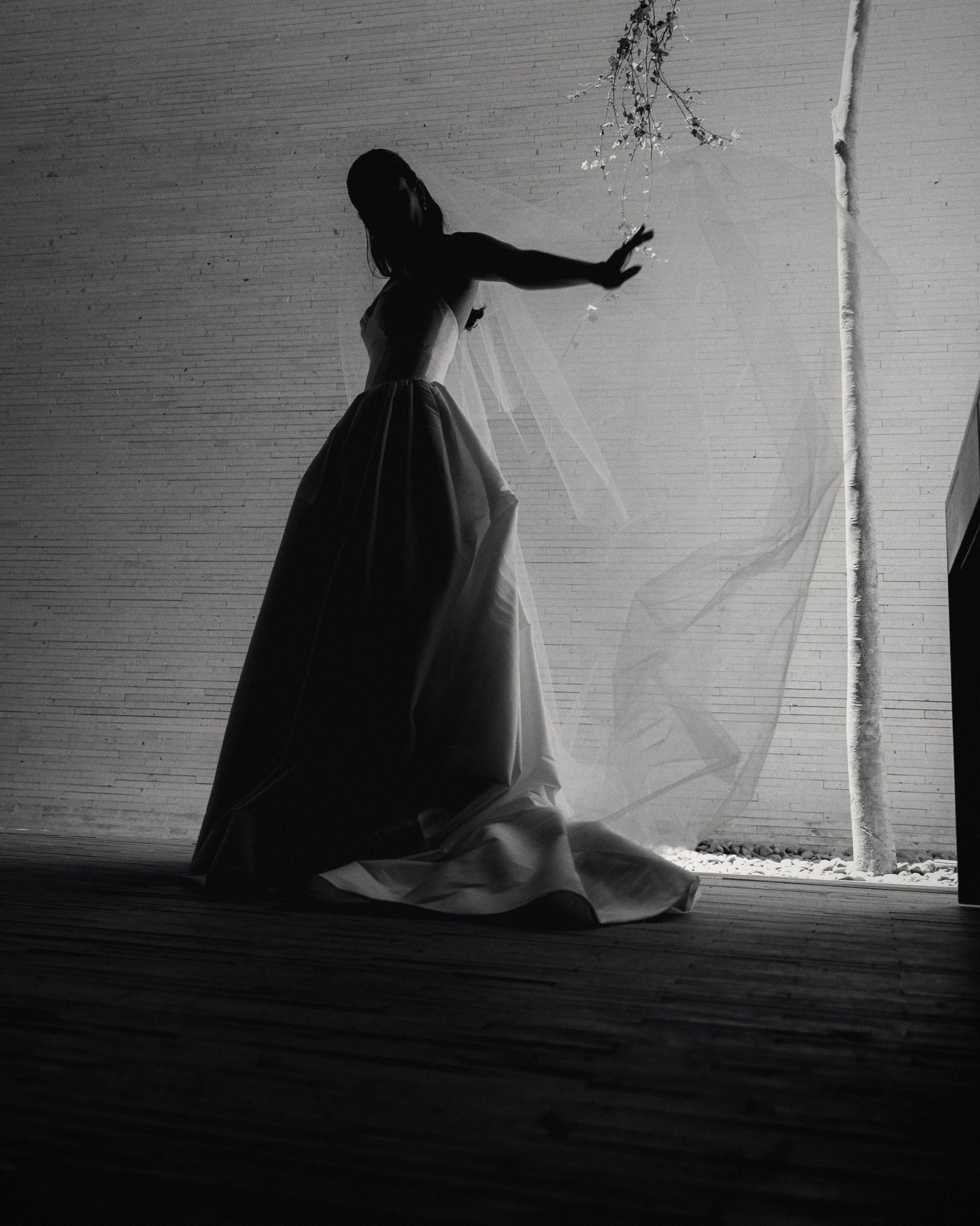Paula dancing alone in her wedding dress in the shade, black and white
